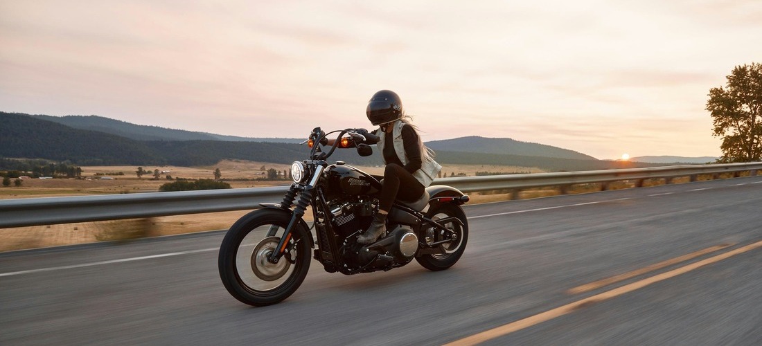 Photo d'une femme circulant sur une route à moto